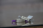 Decorative keychains with motivational phrases on a reflective surface